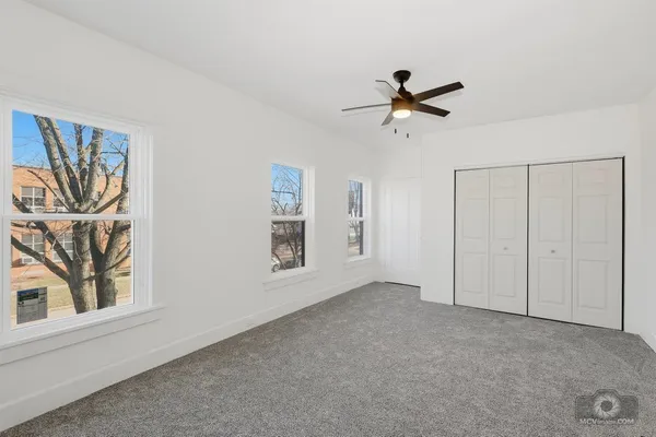 a view of a livingroom with a ceiling fan & window