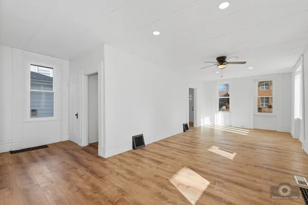 a view of a livingroom with wooden floor and a large window