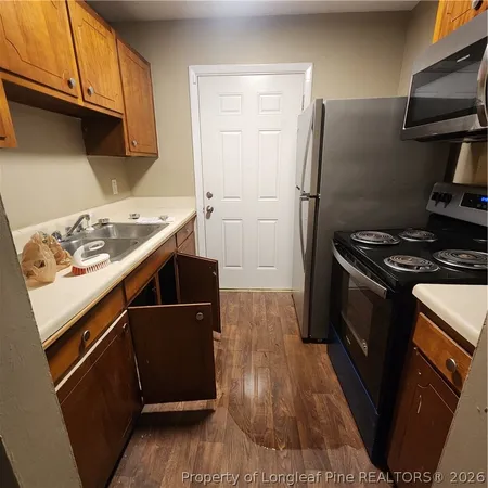 a kitchen with stainless steel appliances granite countertop a refrigerator and a stove top oven