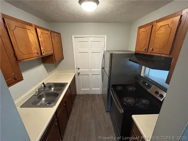 a kitchen with wooden cabinets and a stove top oven