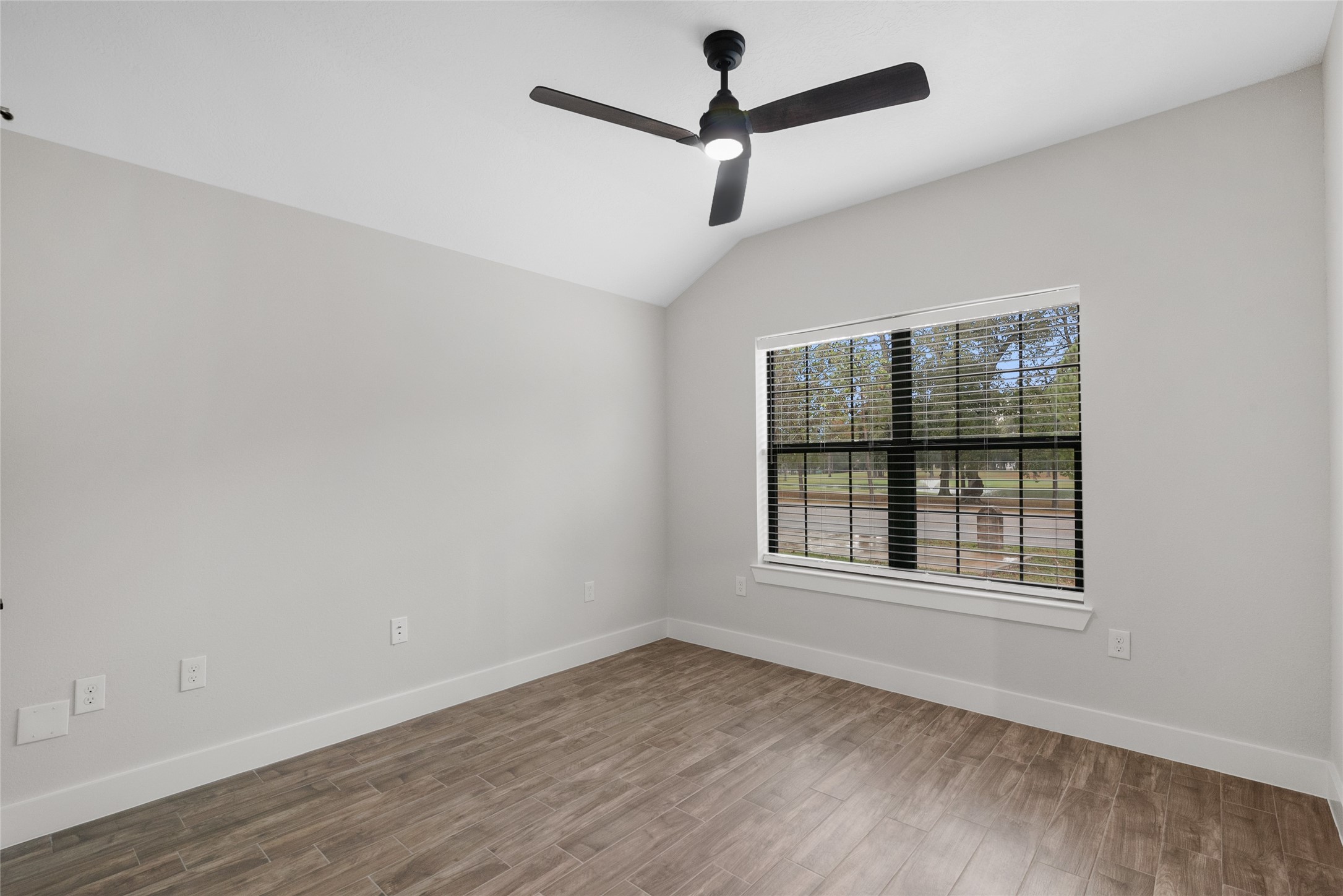 13018 Walden Road, Unit A Montgomery, TX 77356 - Photo 12 of 32 an empty room with wooden floor ceiling fan and windows