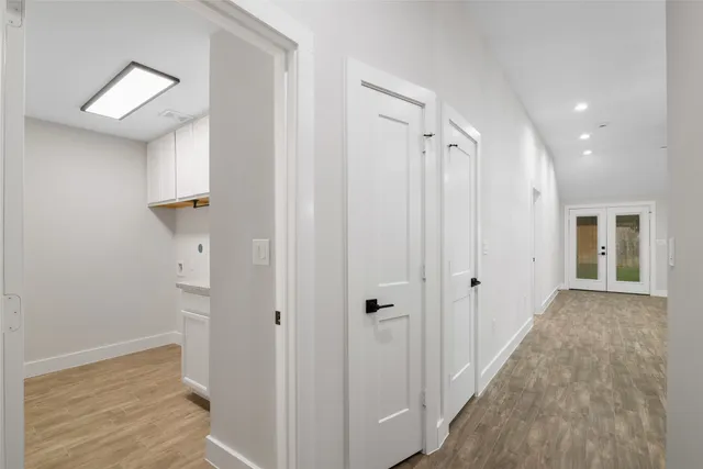 a view of a hallway with wooden floor and closet area