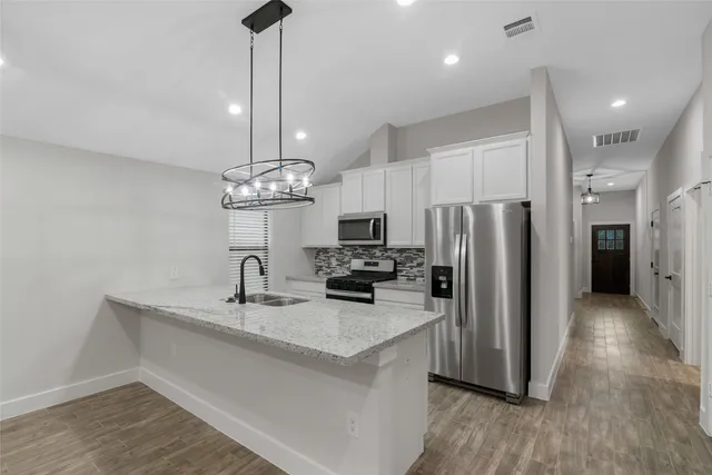 a kitchen with stainless steel appliances a refrigerator sink and microwave