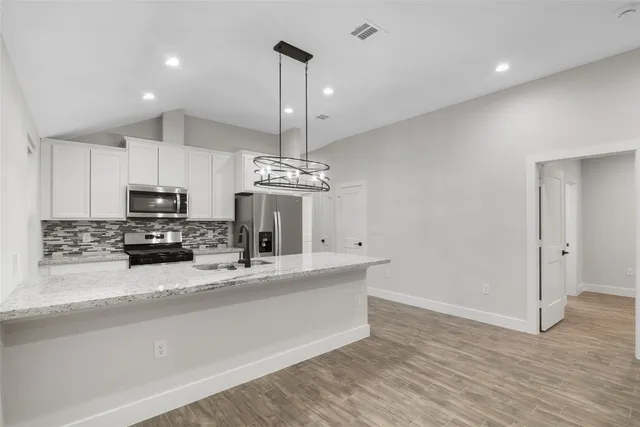 a kitchen with stainless steel appliances a refrigerator sink and microwave