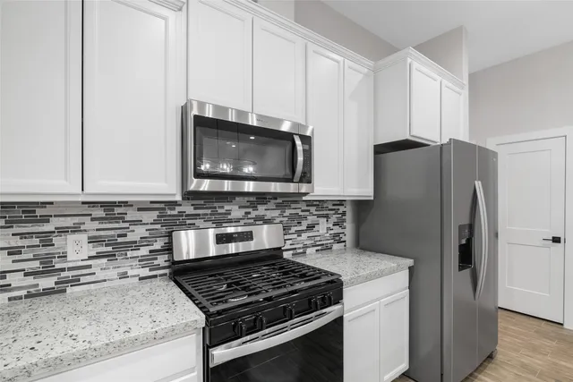 a kitchen with granite countertop a stove and a microwave