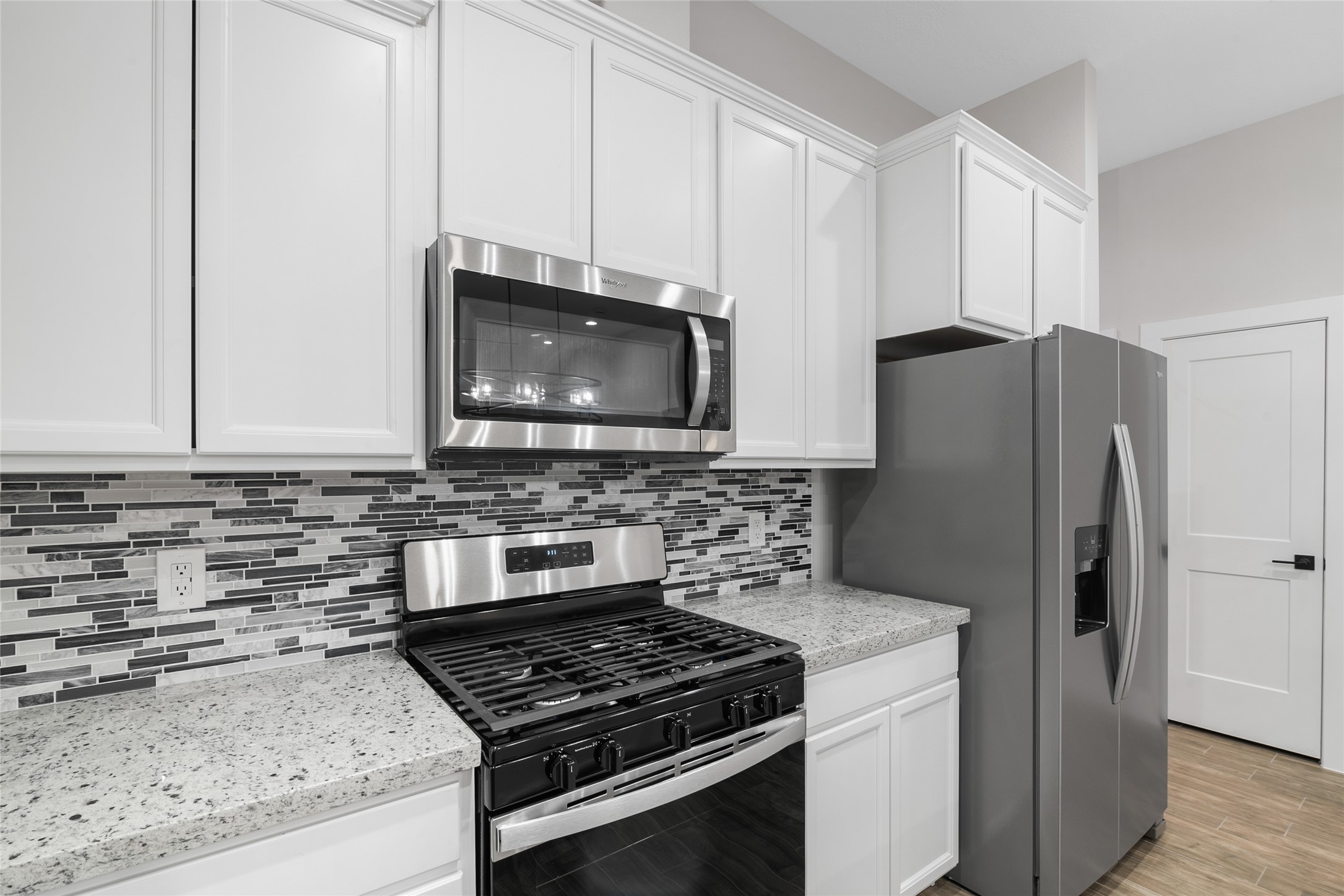 13018 Walden Road, Unit A Montgomery, TX 77356 - Photo 6 of 32 a kitchen with granite countertop a stove and a microwave