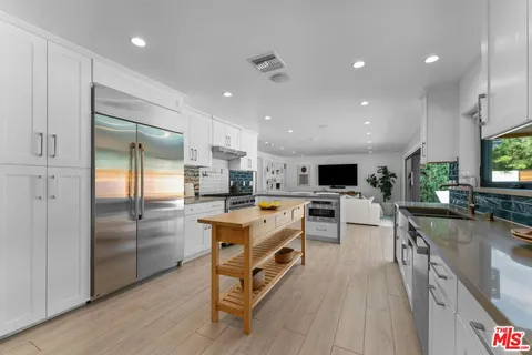 a large kitchen with a large counter top appliances and cabinets