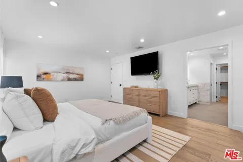 a bedroom with a bed and a flat screen television