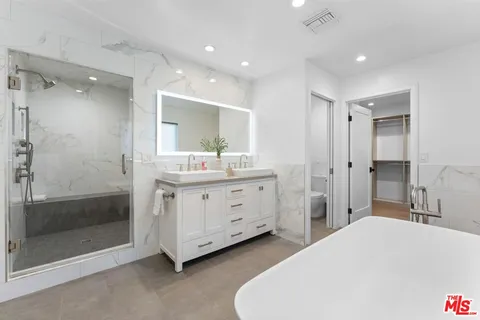 a spacious bathroom with a double vanity sink mirror and double