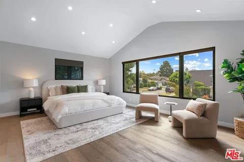 a bedroom with a large bed and a large window