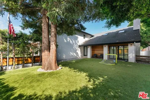 a view of a house with a yard and tree