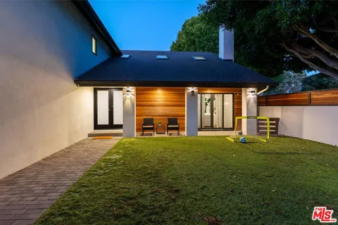 a backyard of a house with table and chairs
