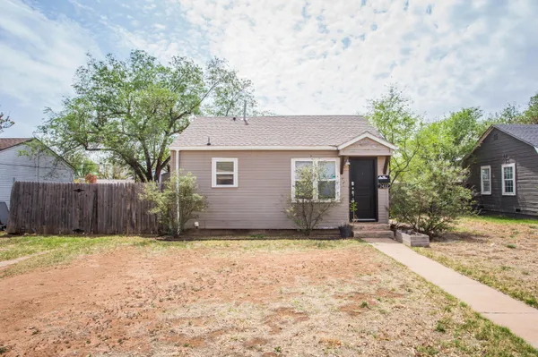 a front view of a house with a garden and yard