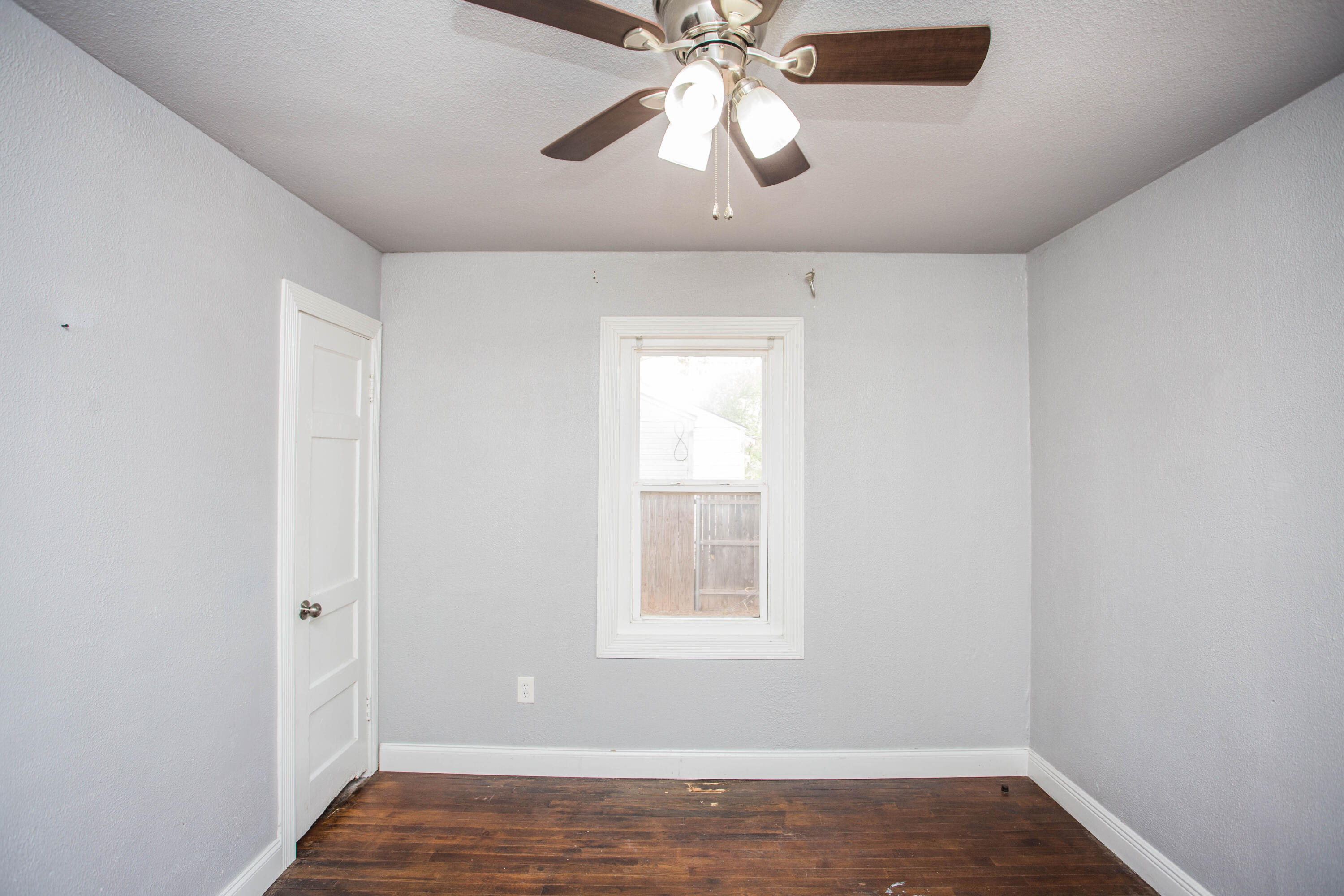 2409 39th Street Lubbock, TX 79412 - Photo 12 of 16 an empty room with a window and a chandelier fan