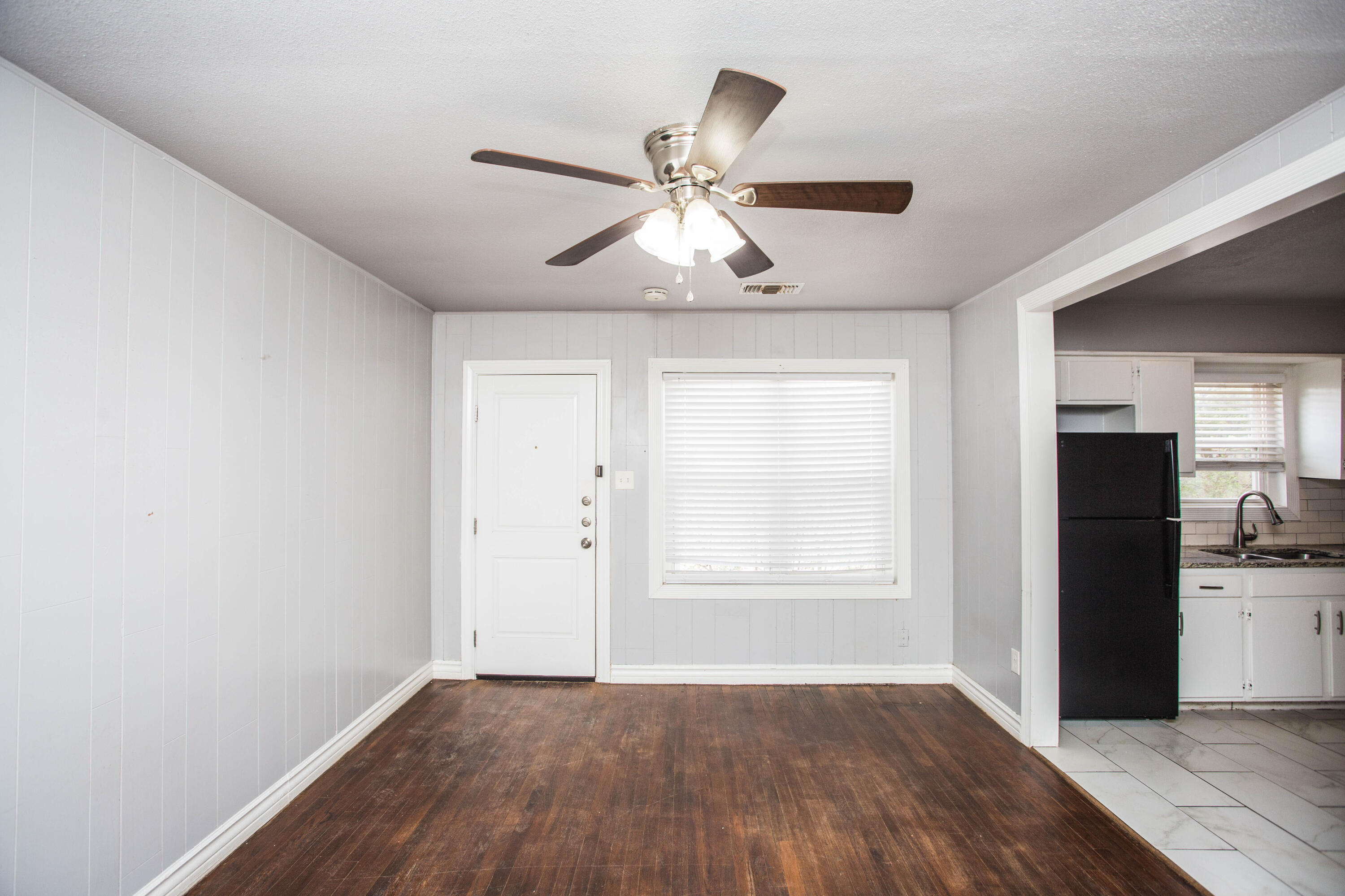 2409 39th Street Lubbock, TX 79412 - Photo 2 of 16 an empty room with wooden floor closet chandelier fan and windows