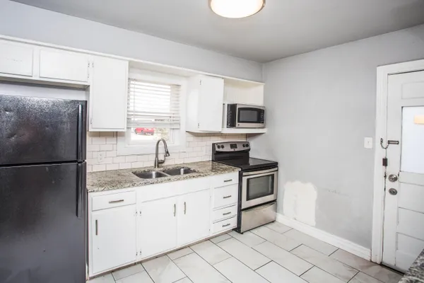 a kitchen with stainless steel appliances granite countertop a refrigerator sink and stove