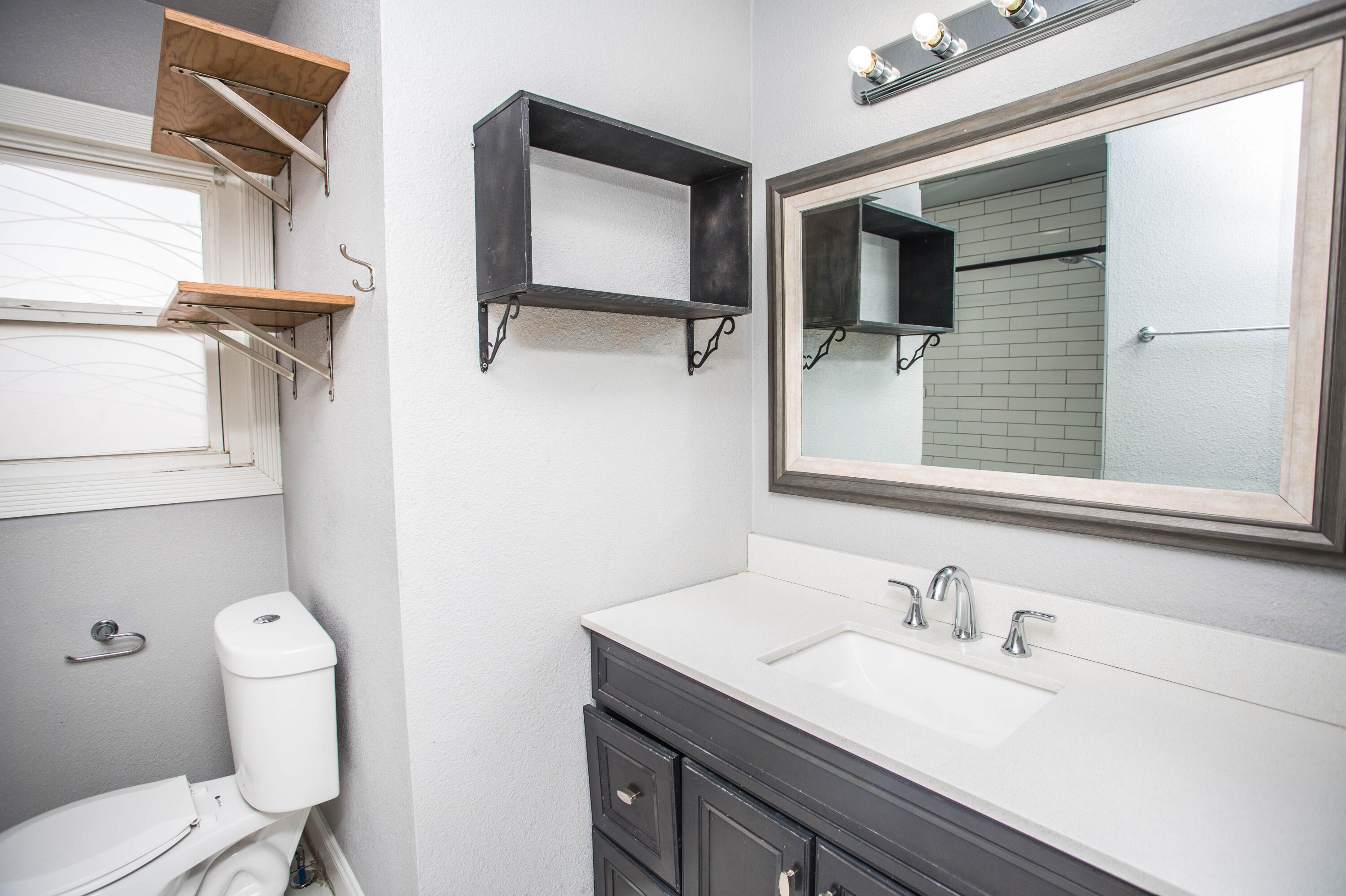 2409 39th Street Lubbock, TX 79412 - Photo 10 of 16 a bathroom with a sink and mirror