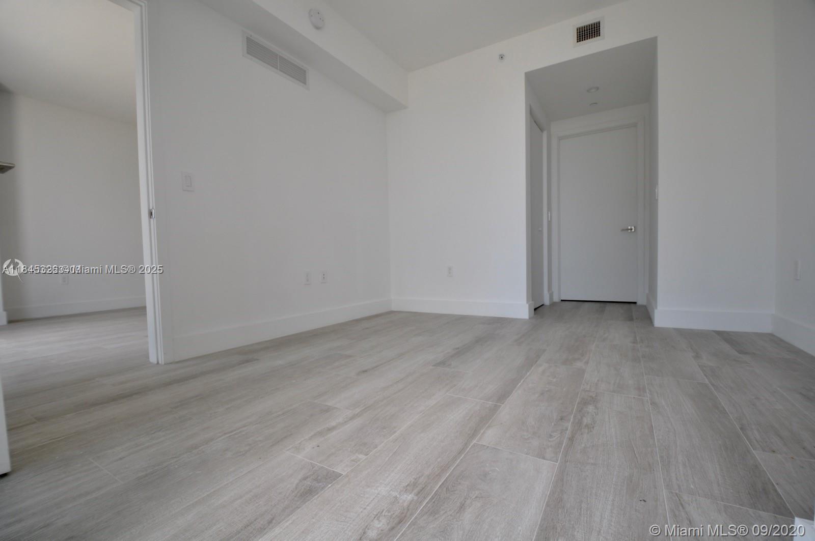 121 Northeast 34th Street, Unit 806 Miami, FL 33137 - Photo 12 of 22 an empty room with wooden floor and closet