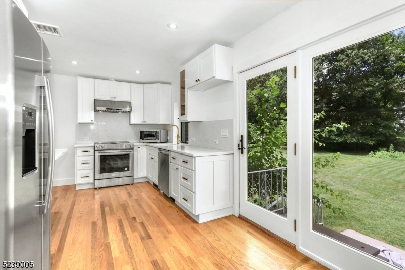 22 Morningside Road Woodbridge, NJ 07067 - Photo 11 of 27 a kitchen with a refrigerator a stove top oven a sink and a large window