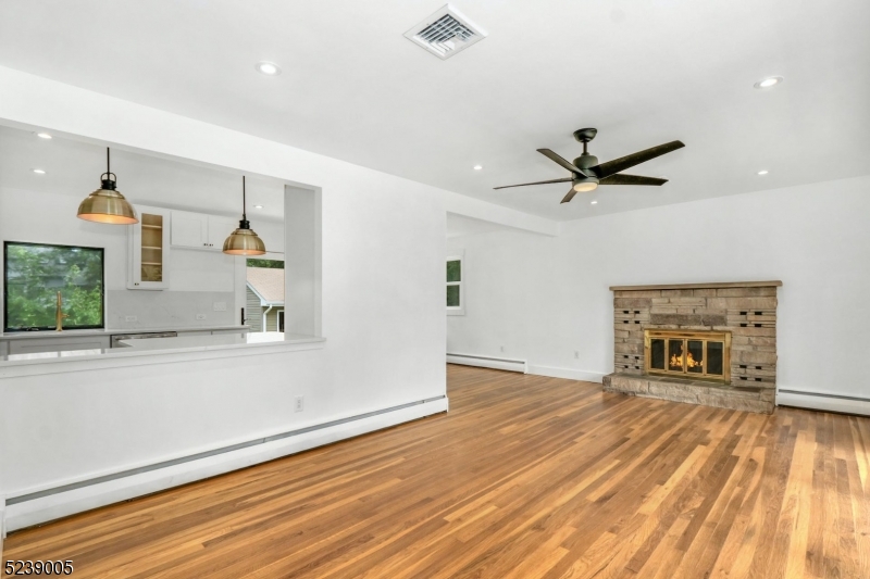 22 Morningside Road Woodbridge, NJ 07067 - Photo 4 of 27 an empty room with wooden floor a ceiling fan and windows