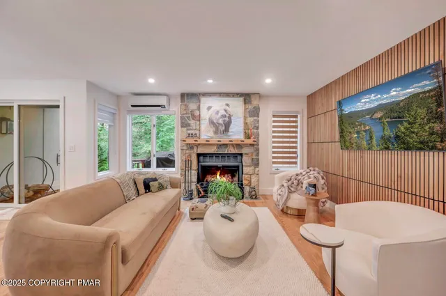 a living room with furniture a fireplace and a large window