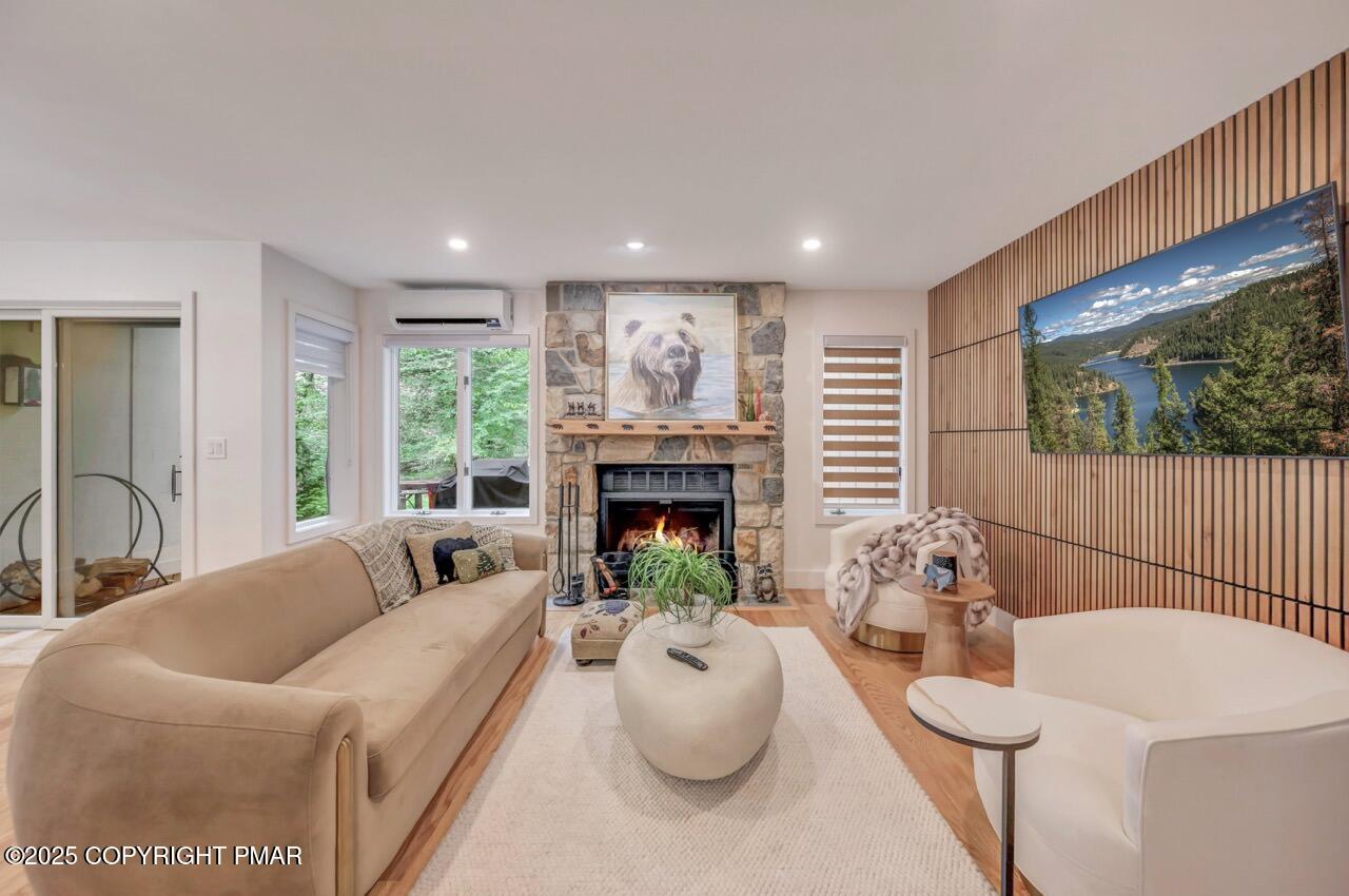 a living room with furniture a fireplace and a large window