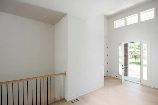 a view of a hallway with wooden floor and windows