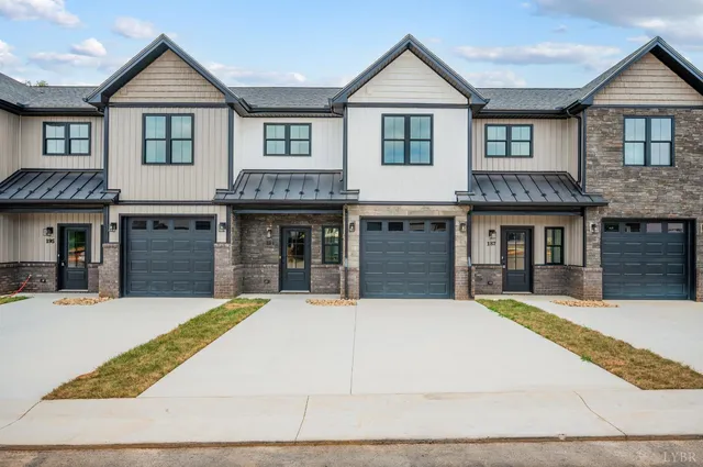 a front view of a house with yard and parking space