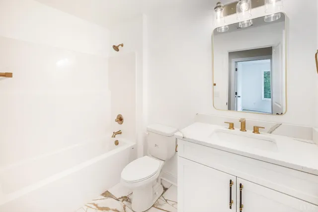 a front view of a house with a yard and potted plants