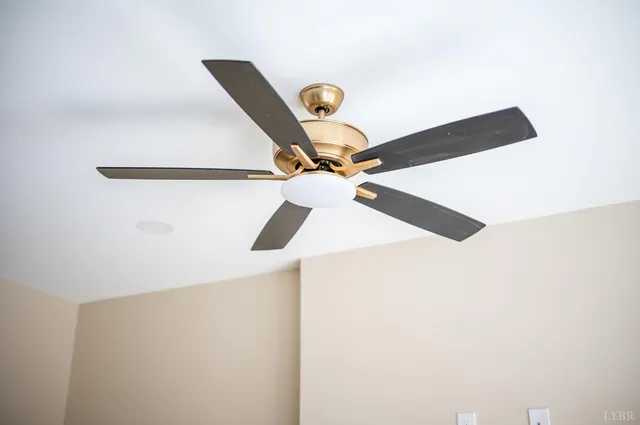 an empty room with a ceiling fan and window