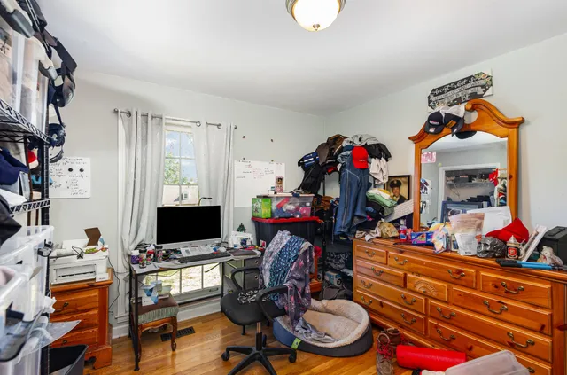 a room with lots of white furniture and flat screen tv