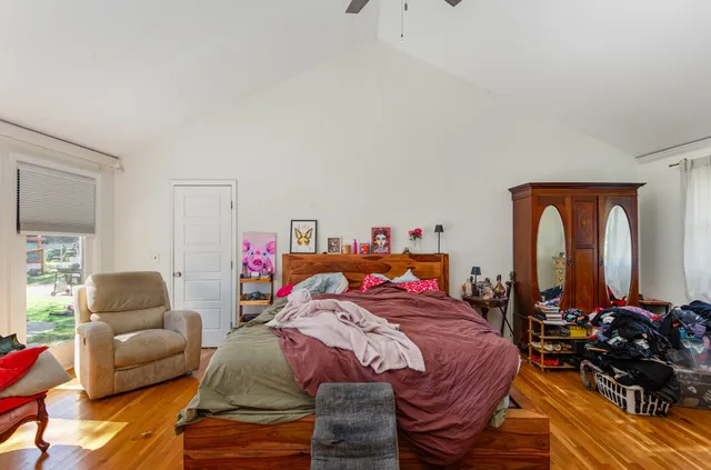 a bedroom with furniture and a large window