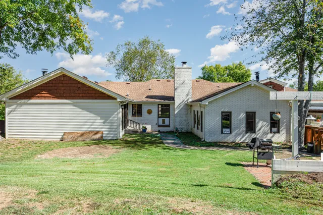 a backyard of a house with table and chairs