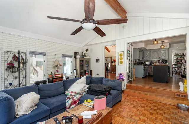 a living room with furniture and kitchen view