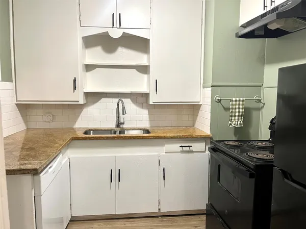 a kitchen with granite countertop a sink stainless steel appliances and cabinets