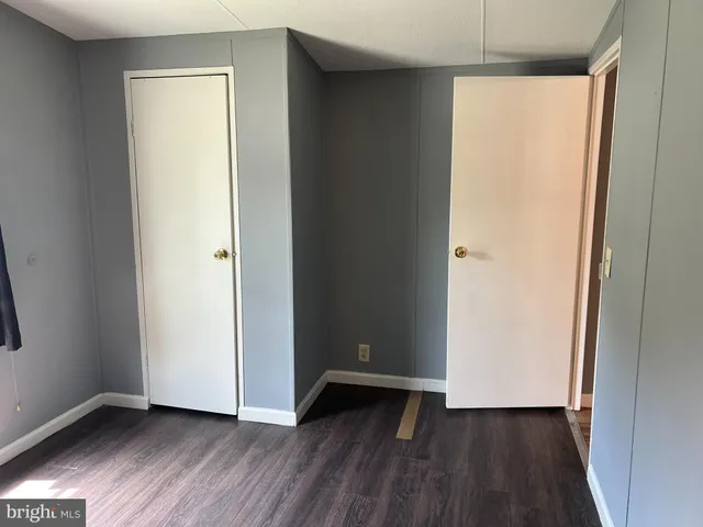 an empty room with wooden floor and closet
