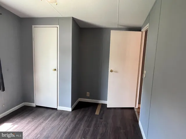 an empty room with wooden floor and a window