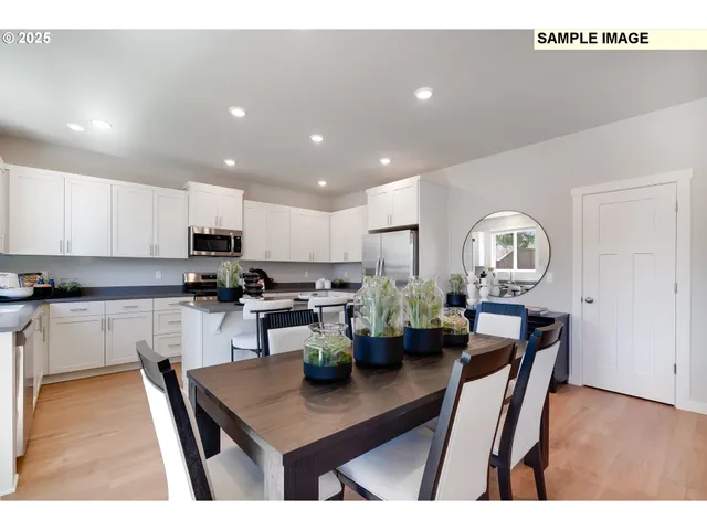 a open kitchen with stainless steel appliances granite countertop a stove a sink a microwave a dining table and chairs