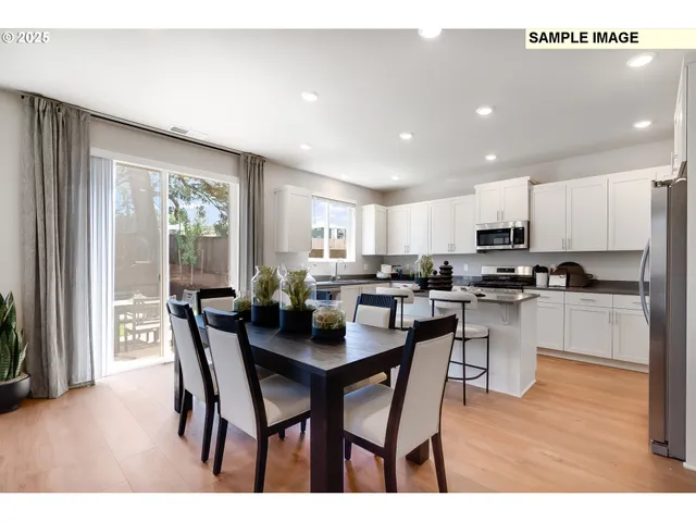 a kitchen with a dining table chairs and refrigerator