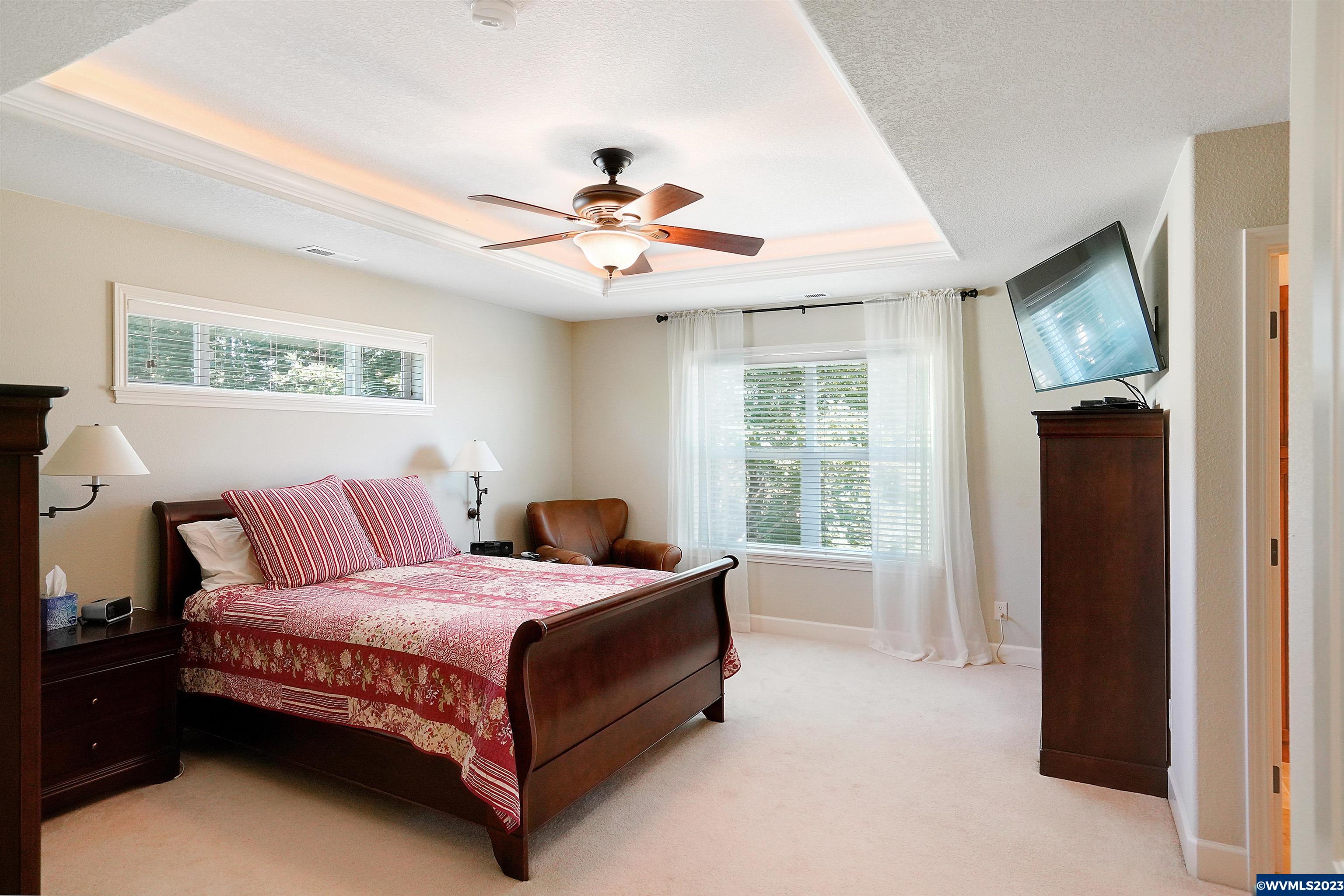 306 Northwest Reed Lane Dallas, OR 97338 - Photo 23 of 42 a bedroom with a large bed and a chandelier fan