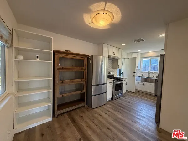 a kitchen with a refrigerator and a stove top oven