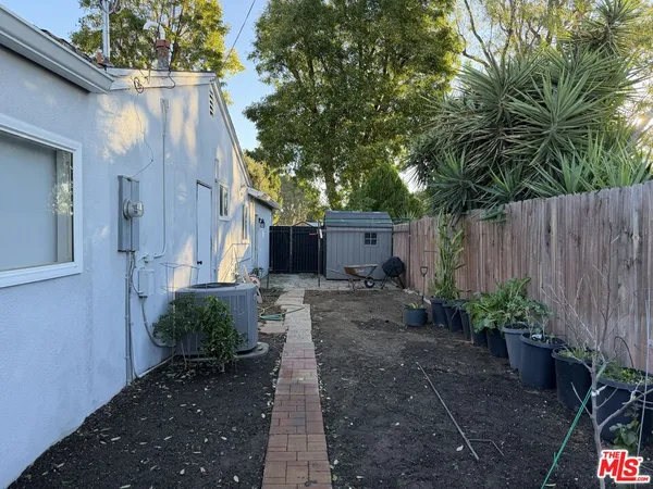 a backyard of a house with plants and tree