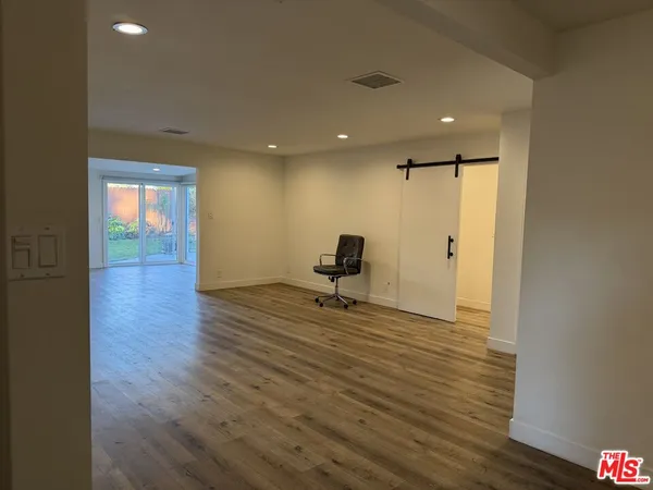 a view of a livingroom with wooden floor and a ceiling fan