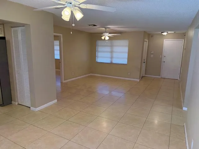 an empty room with fan and entrance