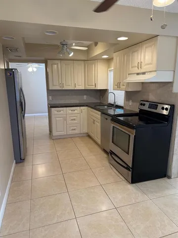 a kitchen with stainless steel appliances granite countertop a stove a sink and a refrigerator