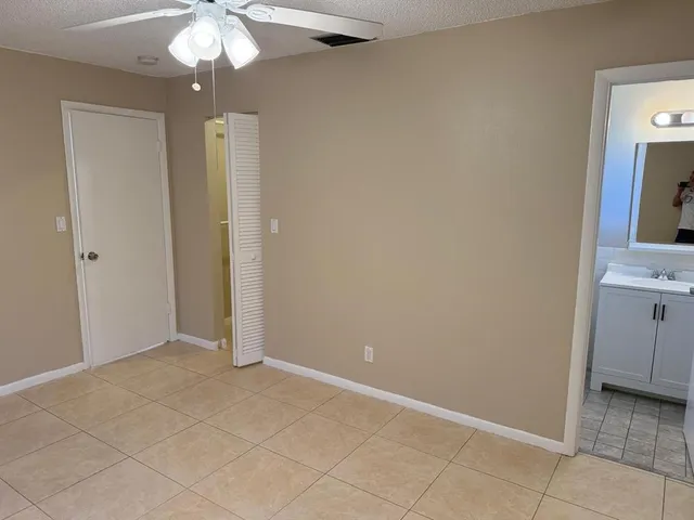 an empty room with chandelier fan