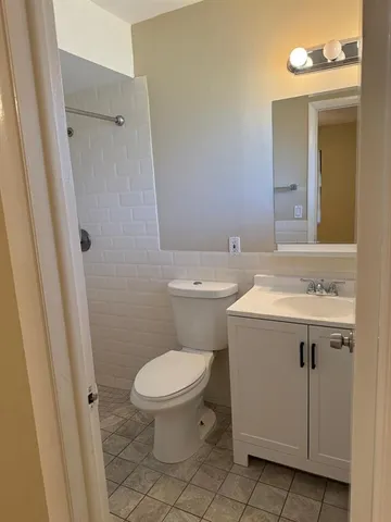 a bathroom with a sink a toilet and a mirror