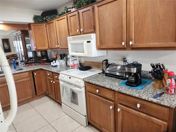 a kitchen with stainless steel appliances granite countertop a sink dishwasher stove and cabinets