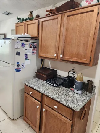 a kitchen with granite countertop a sink a stove and a wooden floor