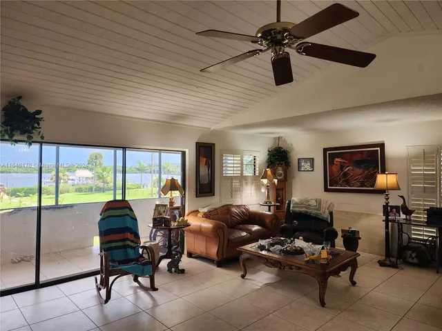 a living room with furniture a ceiling fan and a flat screen tv